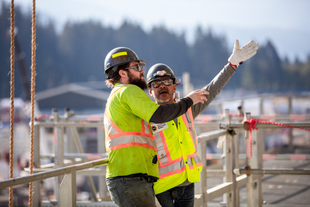 Two construction workers engaged in a discussion at a construction site