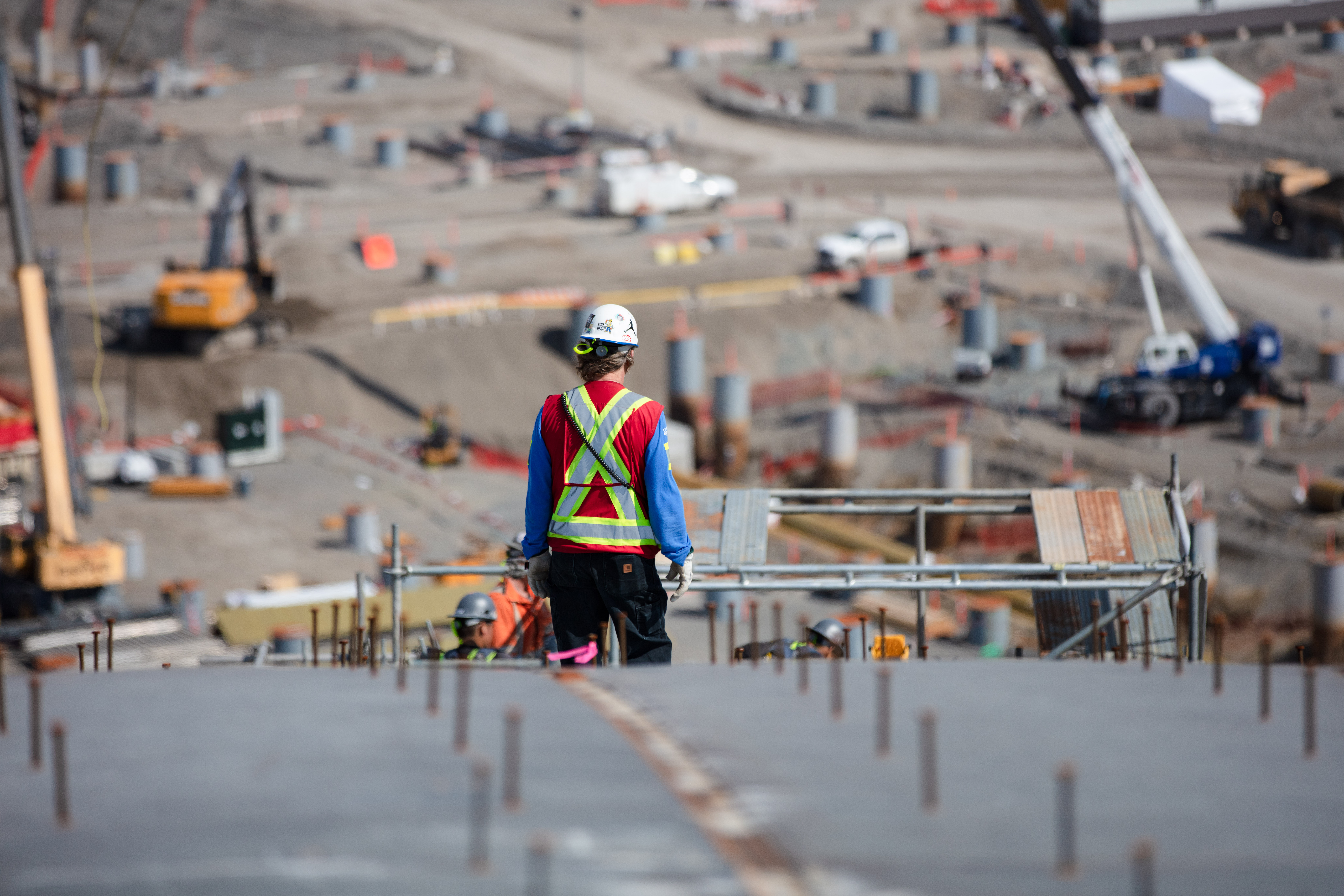 Back shot of a construction worker overseeing progress at a construction site