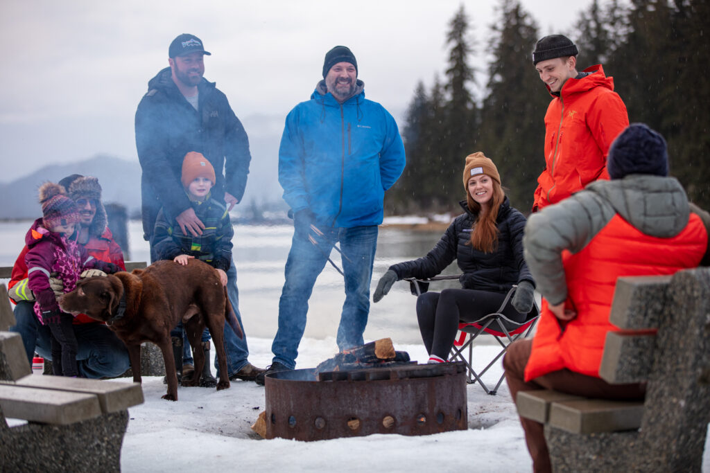 Joyful family gathering around a bonfire on a winter's frozen lake